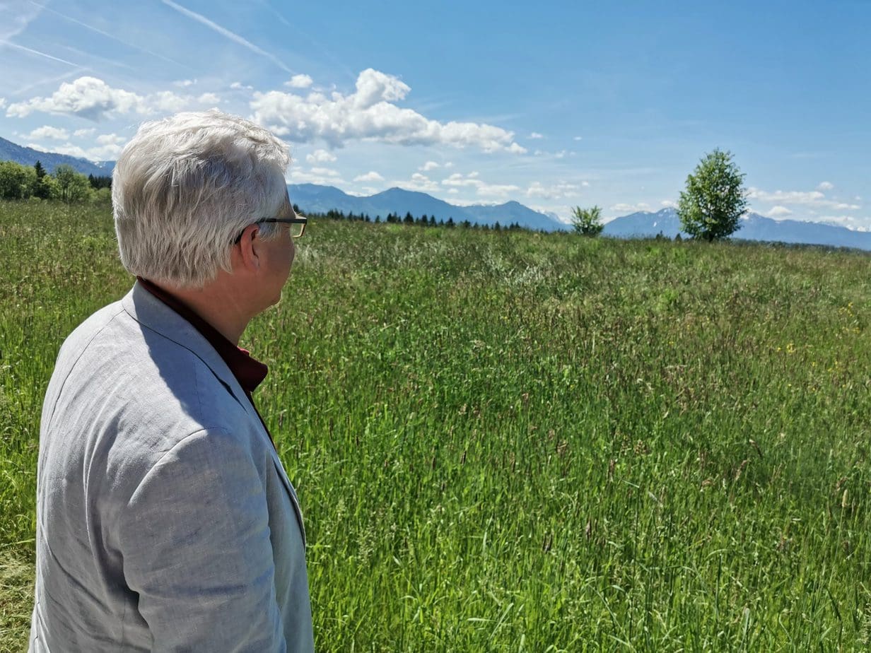 Mediation Schubert: Martin Schubert vor einer grünen Landschaft während er die Aussicht genießt
